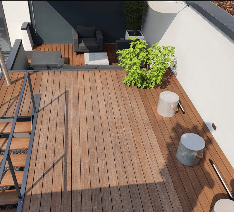 Großzügige Dachterrasse mit Bambus-Terrassendielen, moderner Lounge und Pflanzgefäßen. 